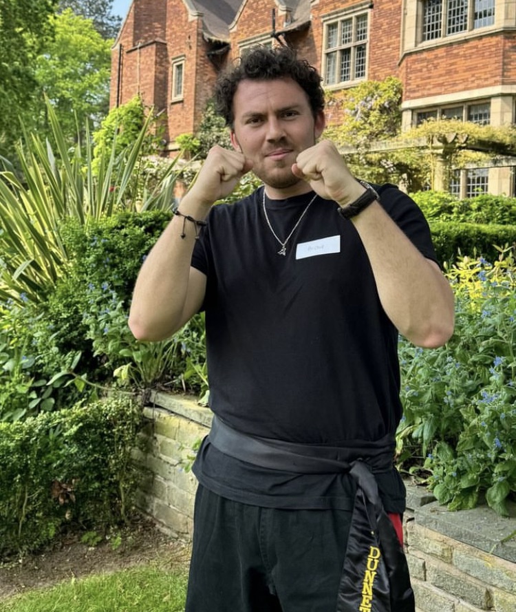 Archie Dunnett, founder of Bamboo Studios, in a guard stance in a garden